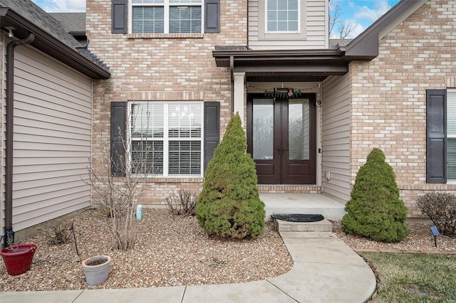 property entrance featuring french doors and brick siding