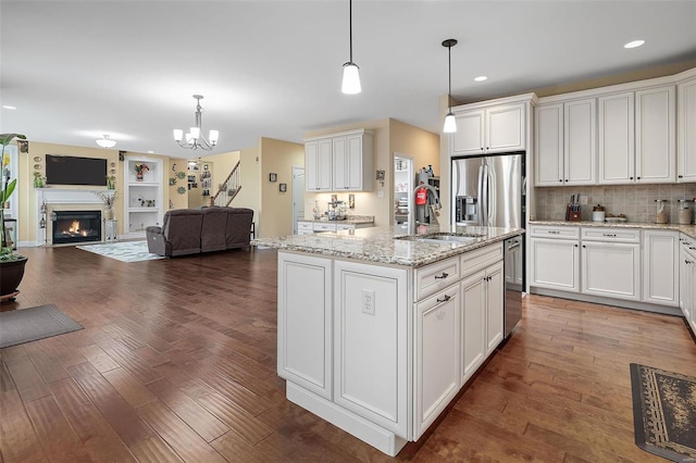 kitchen with open floor plan, a sink, dark wood finished floors, and stainless steel fridge with ice dispenser