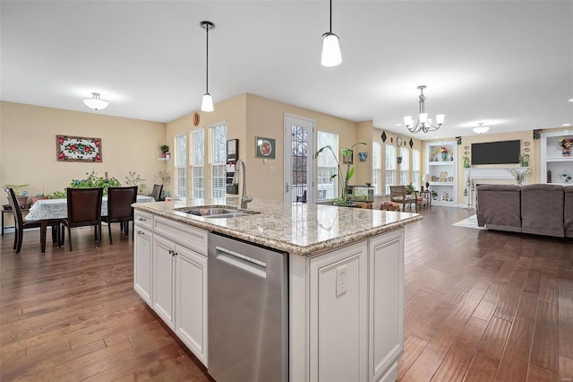 kitchen with a sink, open floor plan, stainless steel dishwasher, and wood finished floors