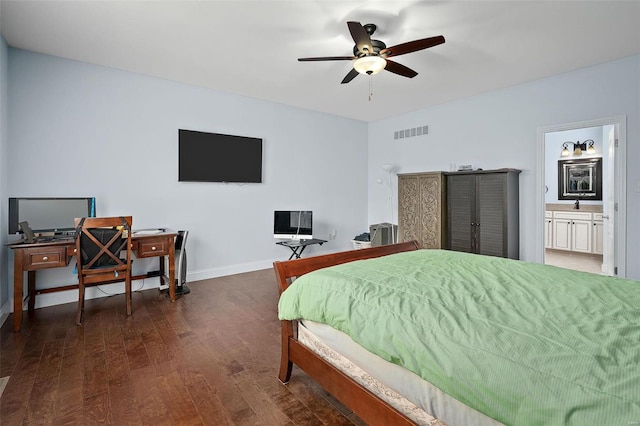 bedroom with wood finished floors, a ceiling fan, visible vents, baseboards, and ensuite bath