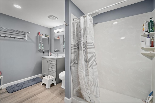 full bath featuring a shower with curtain, baseboards, wood finished floors, and vanity