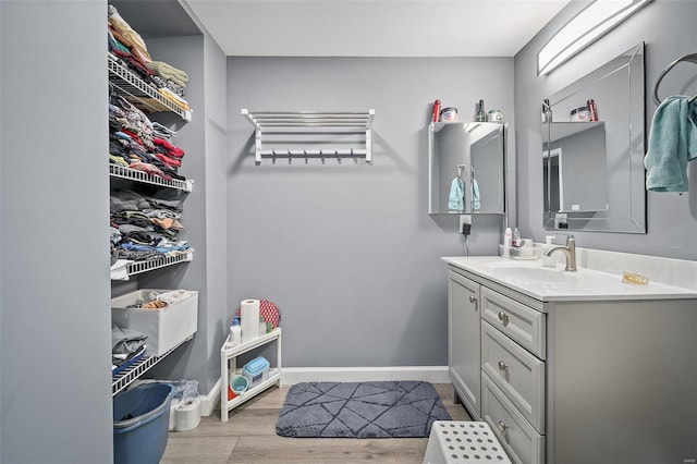 bathroom featuring baseboards, wood finished floors, and vanity