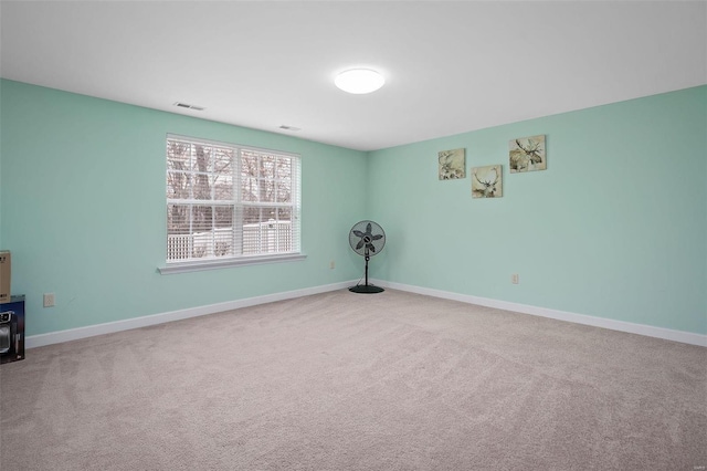 carpeted spare room featuring baseboards and visible vents