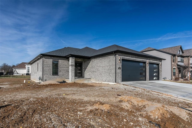 view of front of house featuring an attached garage, roof with shingles, concrete driveway, and brick siding