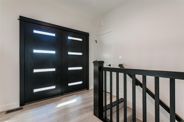 entrance foyer with light wood-style floors, french doors, visible vents, and baseboards