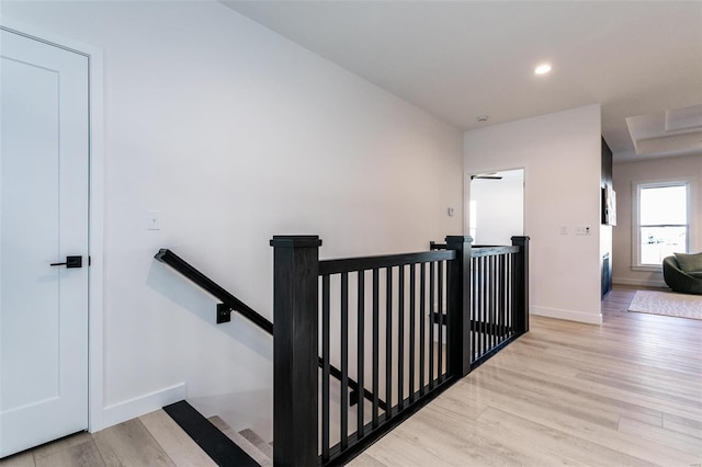 interior space with baseboards, wood finished floors, and an upstairs landing