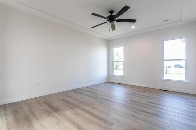 unfurnished room featuring visible vents, a ceiling fan, light wood-style flooring, and baseboards