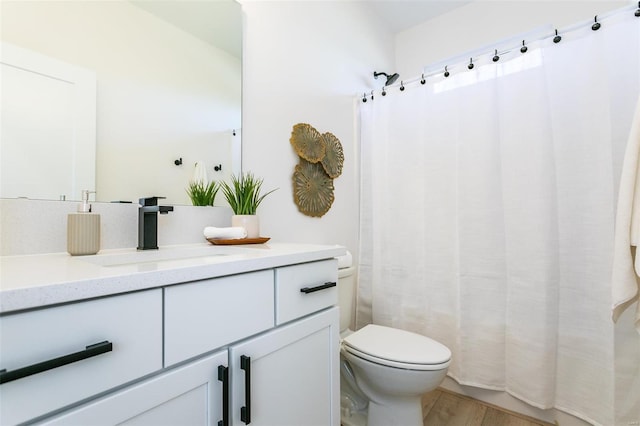 bathroom with curtained shower, vanity, toilet, and wood finished floors