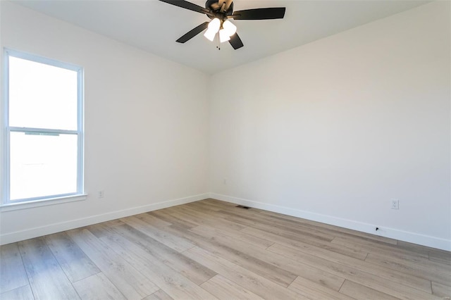 empty room featuring ceiling fan, visible vents, light wood-style flooring, and baseboards