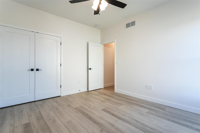 unfurnished bedroom featuring visible vents, baseboards, light wood-style flooring, ceiling fan, and a closet