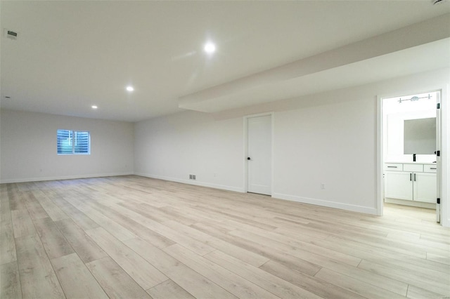 spare room with light wood finished floors, recessed lighting, visible vents, and baseboards