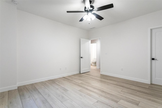 empty room featuring a ceiling fan, baseboards, visible vents, and light wood finished floors