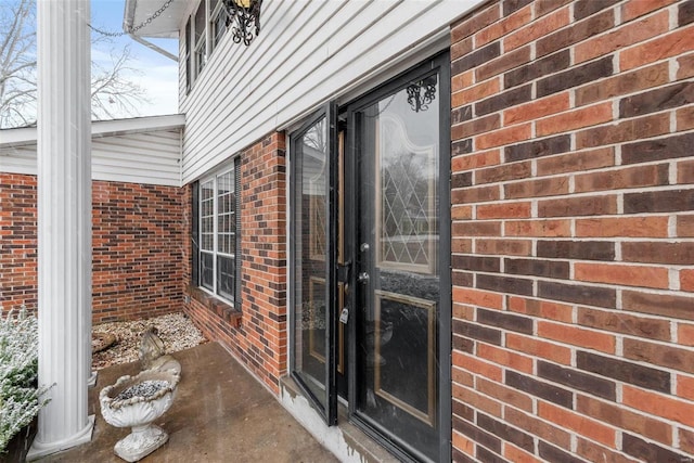 doorway to property featuring brick siding