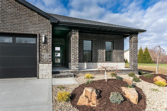 entrance to property featuring brick siding, roof with shingles, and an attached garage