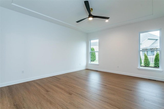 empty room with ceiling fan, recessed lighting, wood finished floors, visible vents, and baseboards