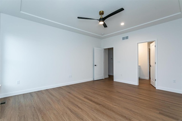 unfurnished bedroom featuring wood finished floors, visible vents, and baseboards