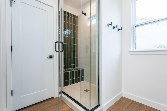 bathroom featuring a stall shower, a wealth of natural light, and wood finished floors