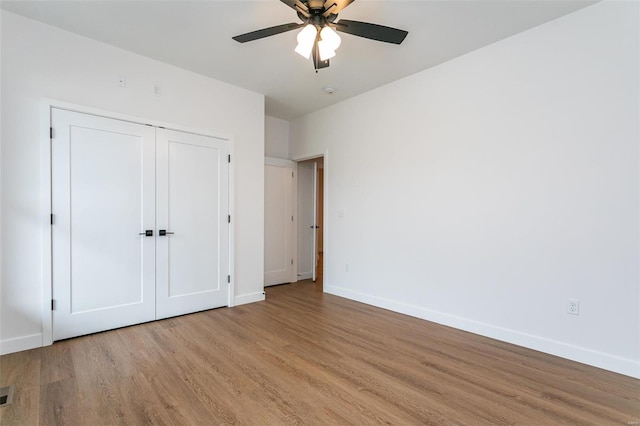 unfurnished bedroom featuring a closet, visible vents, ceiling fan, light wood-type flooring, and baseboards