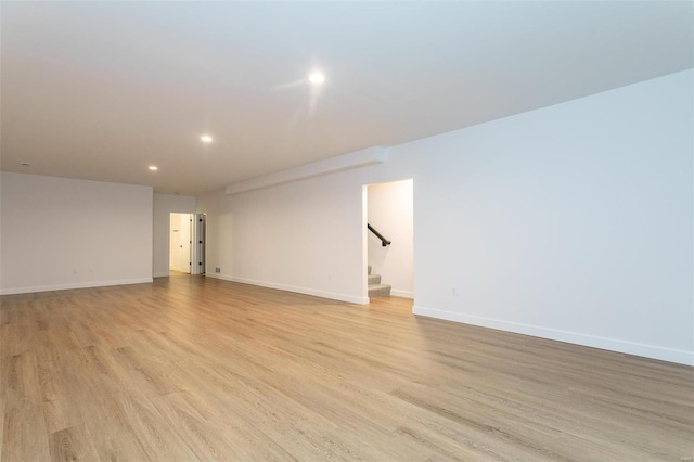 spare room with light wood-style flooring, recessed lighting, stairway, and baseboards