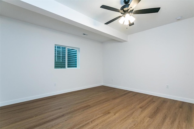 unfurnished room featuring a ceiling fan, visible vents, baseboards, and wood finished floors