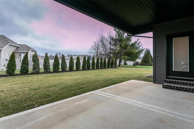 yard at dusk featuring a patio area