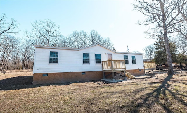 rear view of property featuring crawl space, a yard, a deck, and stairway