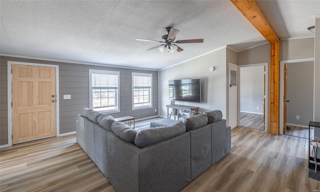 living area with light wood-style flooring, a textured ceiling, crown molding, and vaulted ceiling