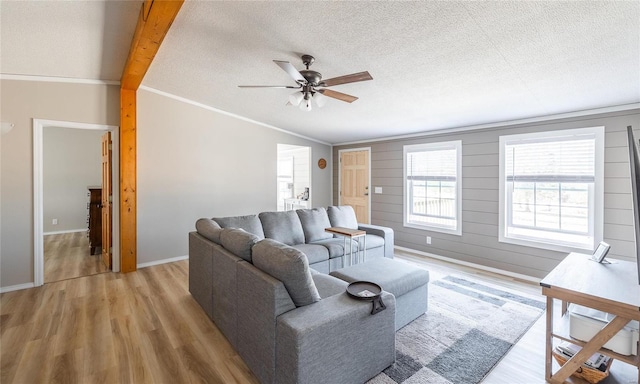 living area featuring light wood finished floors, a textured ceiling, and vaulted ceiling with beams