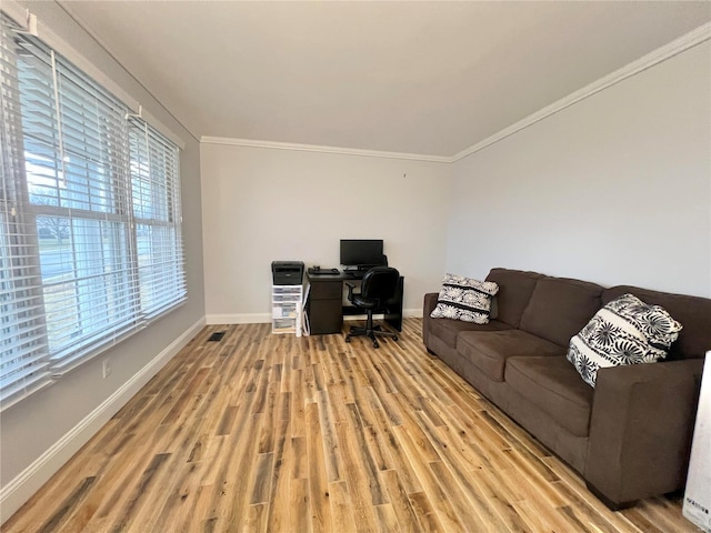 office space featuring baseboards, ornamental molding, visible vents, and light wood-style floors