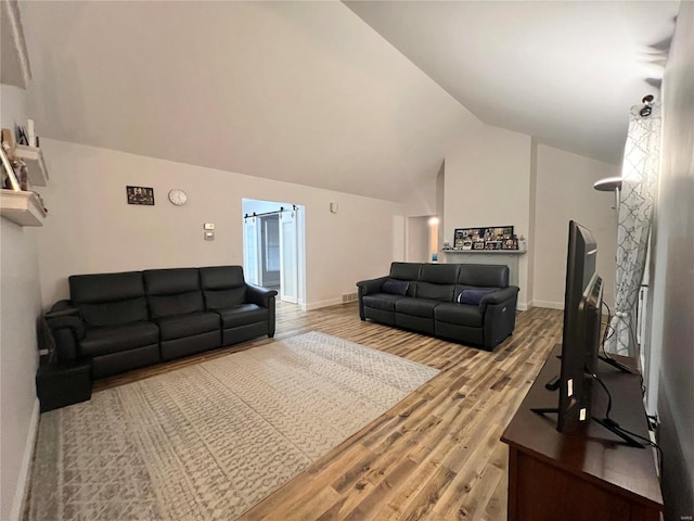 living area with high vaulted ceiling, baseboards, and wood finished floors