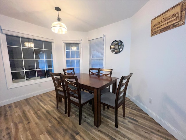 dining space with baseboards and wood finished floors