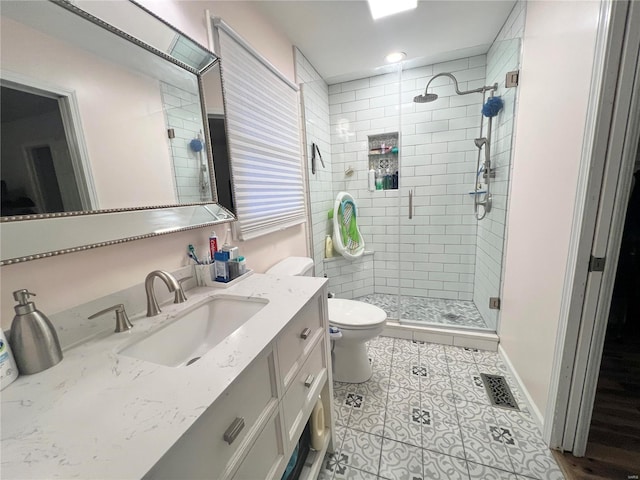 full bath with visible vents, toilet, a shower stall, vanity, and baseboards