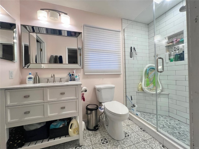 bathroom with vanity, a shower stall, toilet, and tile patterned floors