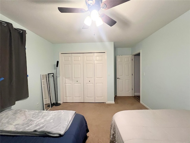 bedroom with a ceiling fan, a closet, carpet flooring, and baseboards