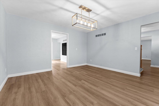 spare room featuring visible vents, light wood-type flooring, and baseboards