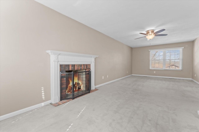 unfurnished living room with baseboards, carpet, a brick fireplace, and a ceiling fan