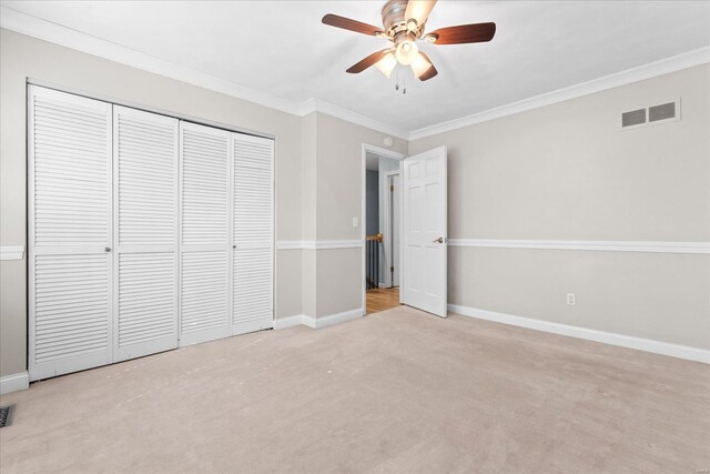 unfurnished bedroom featuring crown molding, carpet, visible vents, and baseboards