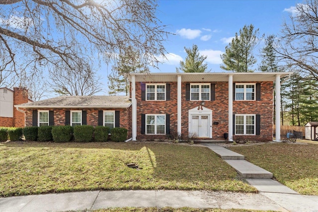 view of front of property featuring a front lawn and brick siding