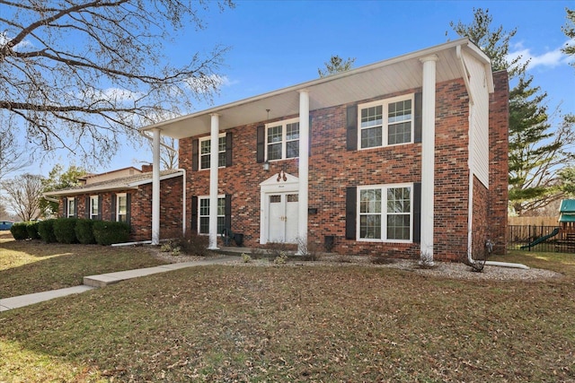 view of front of home featuring a front lawn, fence, and brick siding