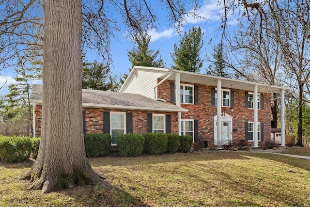 view of front of house with brick siding and a front lawn