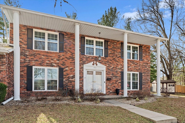 view of front of house featuring a storage shed, brick siding, and an outdoor structure