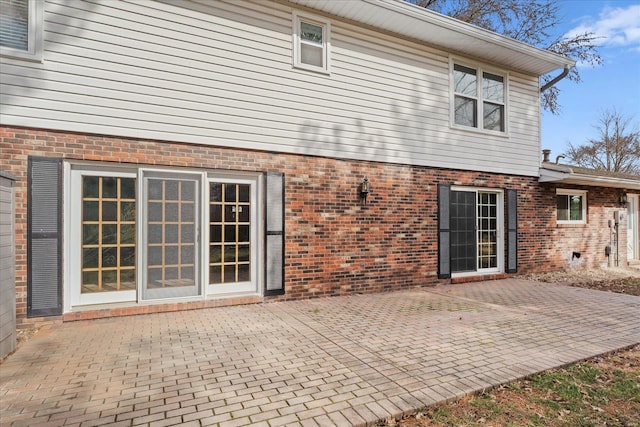 rear view of property with a patio area and brick siding