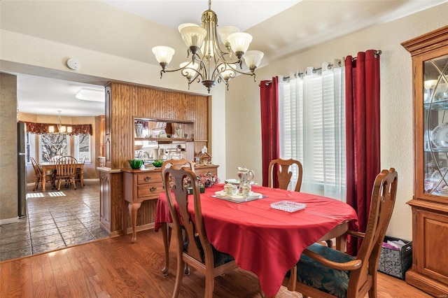 dining space with light wood finished floors, baseboards, and a chandelier