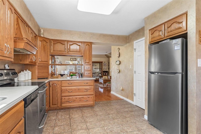 kitchen with stainless steel appliances, brown cabinets, light countertops, and baseboards