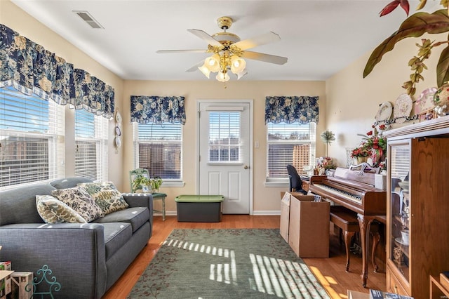 interior space featuring visible vents, ceiling fan, baseboards, and wood finished floors