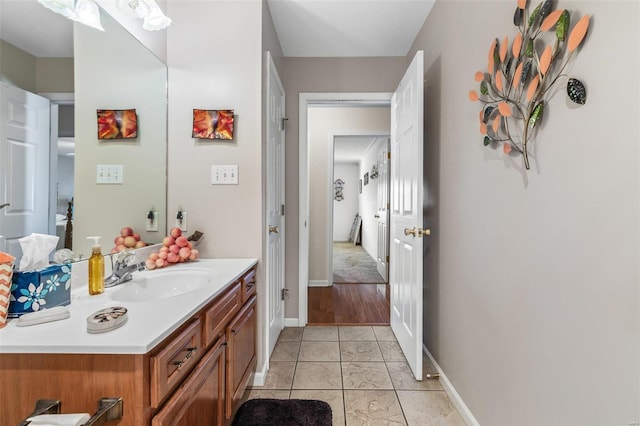 bathroom with tile patterned floors, baseboards, and vanity