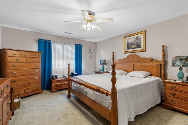 bedroom with light colored carpet, ceiling fan, and visible vents