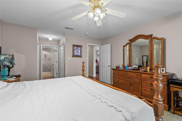 bedroom with ceiling fan, visible vents, and connected bathroom