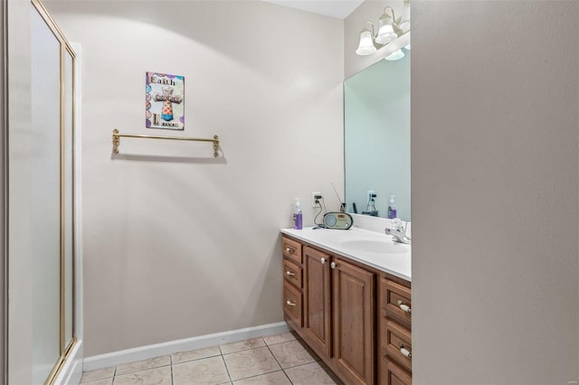 bathroom with a stall shower, vanity, baseboards, and tile patterned floors