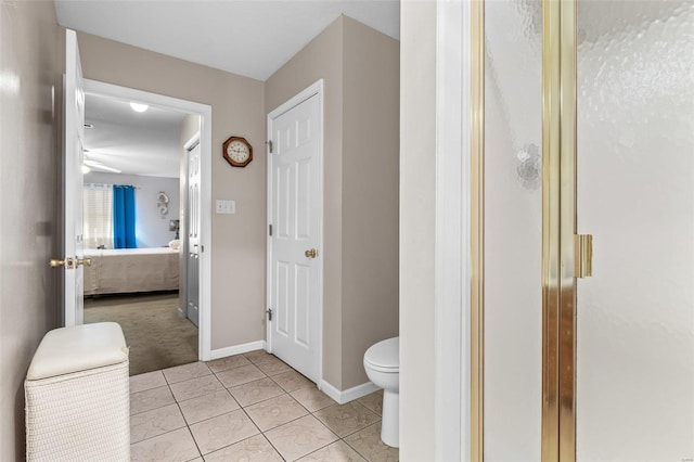 full bathroom featuring baseboards, toilet, ensuite bathroom, tile patterned floors, and a shower stall